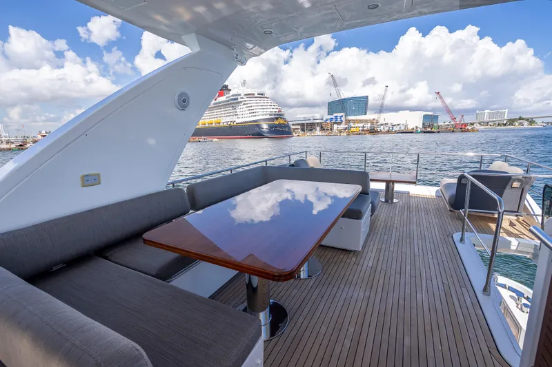  Yacht Photos Pics Luxurious 2019 Azimut 66 yacht deck with elegant seating, overlooking a bustling harbor.