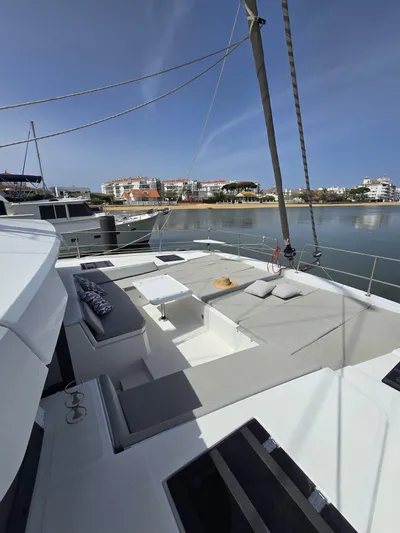 Catacha Yacht Photos Pics Modern Bali 4.6 catamaran deck with seating, docked by calm waters, 2022 model.
