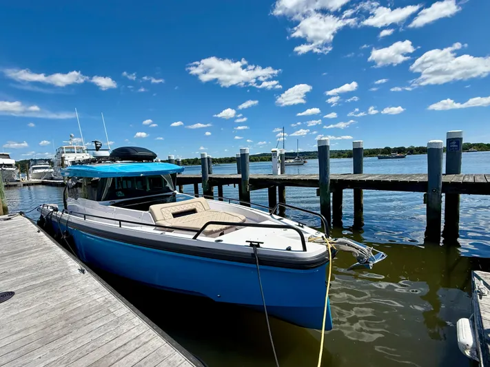 Good Vibes Yacht Photos Pics 2023 Axopar 37 Cross Cabin docked under a clear blue sky.