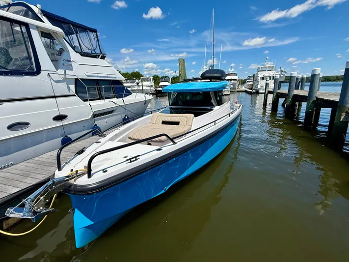 Good Vibes Yacht Photos Pics 2023 Axopar 37 Cross Cabin boat docked at a marina under a clear blue sky.