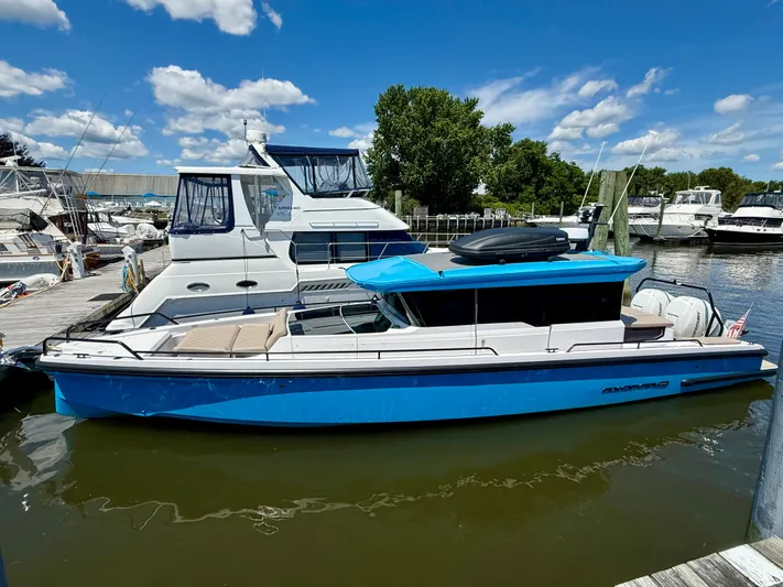Good Vibes Yacht Photos Pics 2023 Axopar 37 Cross Cabin boat docked at marina under blue sky.