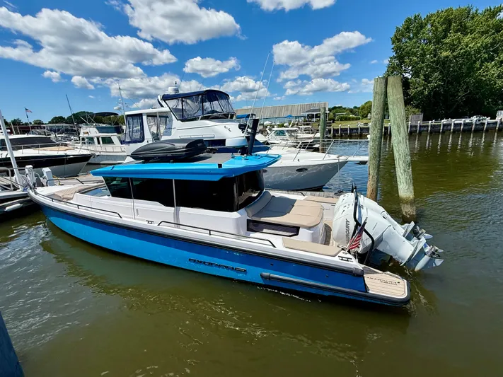 Good Vibes Yacht Photos Pics 2023 Axopar 37 Cross Cabin boat docked in a marina under a blue sky.