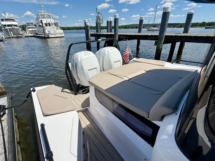 Good Vibes Yacht Photos Pics 2023 Axopar 37 Cross Cabin docked with twin engines and sun deck, under a clear sky.