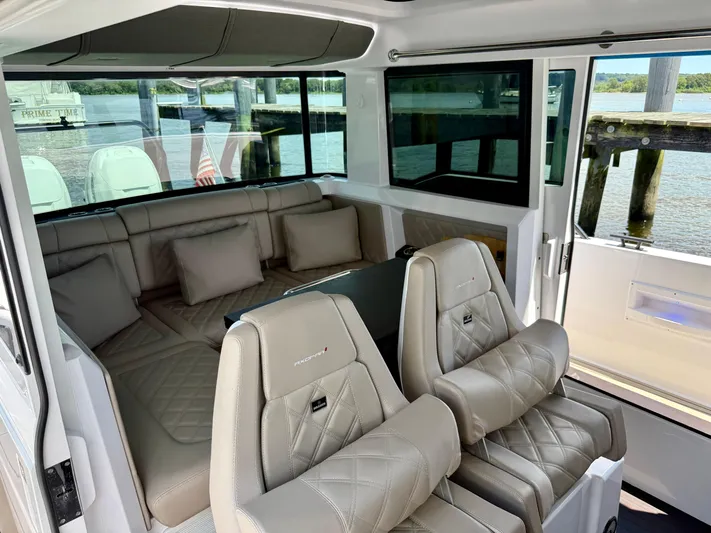 Good Vibes Yacht Photos Pics Interior of 2023 Axopar 37 Cross Cabin with luxurious seating and waterfront view.