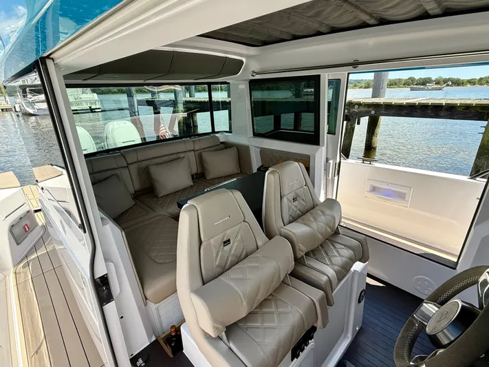 Good Vibes Yacht Photos Pics Interior of 2023 Axopar 37 Cross Cabin with luxurious seating and waterfront view.