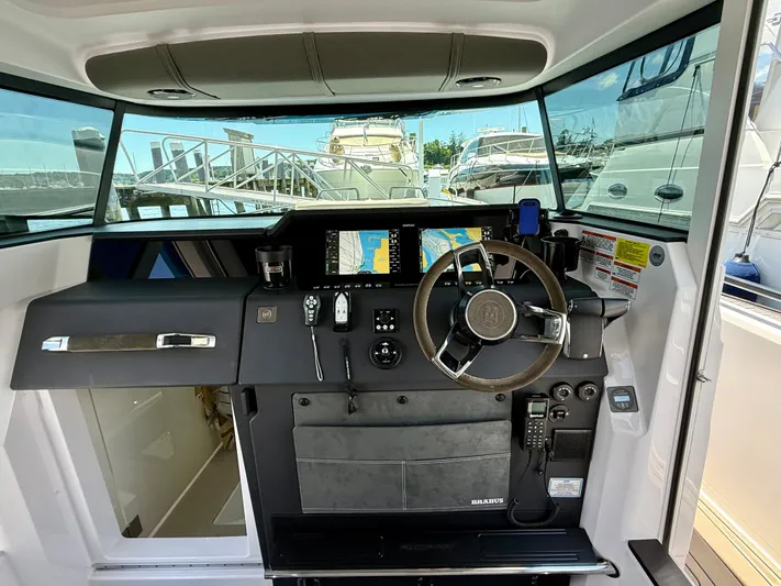 Good Vibes Yacht Photos Pics 2023 Axopar 37 Cross Cabin helm with modern navigation equipment and steering wheel.