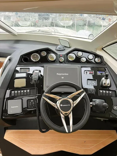  Yacht Photos Pics Control panel of a 2008 Absolute 56 yacht with steering wheel and navigation instruments.