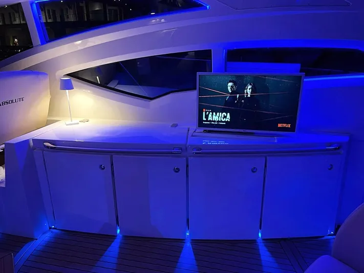  Yacht Photos Pics Luxury yacht interior with blue lighting, featuring a TV displaying a Netflix show. Absolute 56, 2008 model.