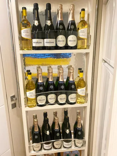  Yacht Photos Pics Wine and champagne bottles displayed on shelves in a well-organized storage unit.
