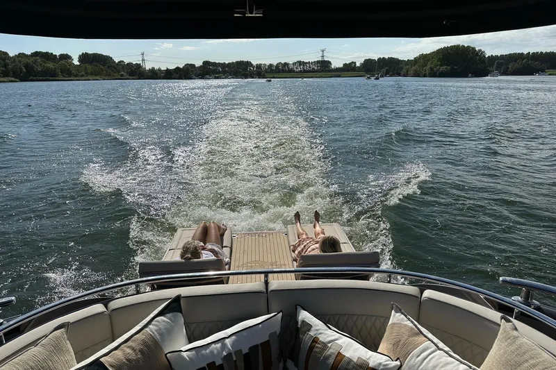 Baateaux Yacht Photos Pics 2024 Zeelander 5 yacht cruising with passengers relaxing on deck, scenic water view.