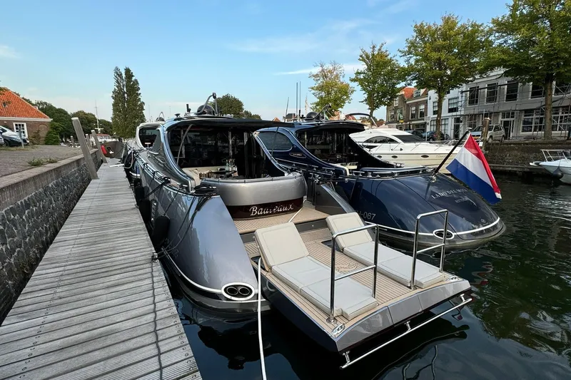 Baateaux Yacht Photos Pics 2024 Zeelander 5 yacht docked, featuring sleek design and Dutch flag, in a scenic marina.