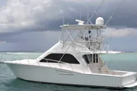 2007 Cabo 43 FB yacht on calm turquoise waters under cloudy skies.