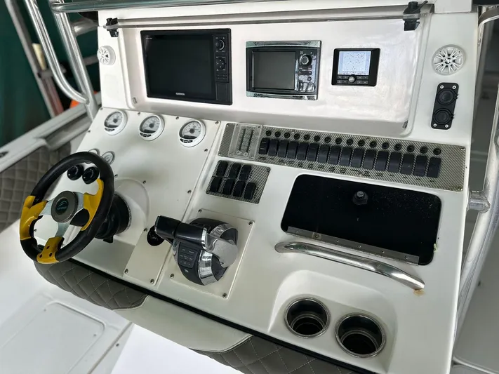  Yacht Photos Pics Control panel of a 2003 Fountain 34 CC boat with steering wheel and navigation instruments.