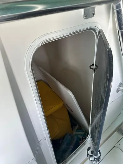  Yacht Photos Pics Open storage compartment on 2003 Fountain 34 CC boat with yellow life jacket inside.