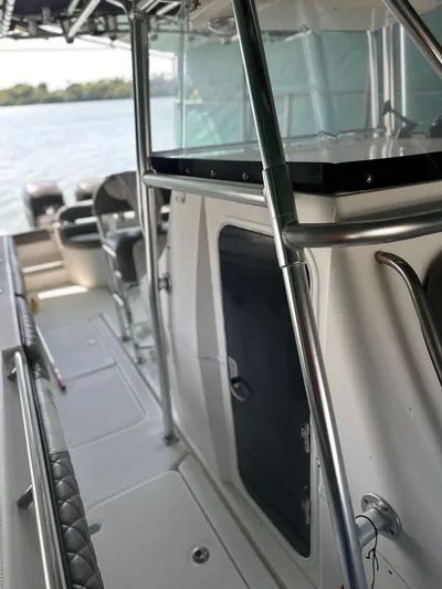  Yacht Photos Pics 2003 Fountain 34 CC boat interior with seating and railing, docked by the water.