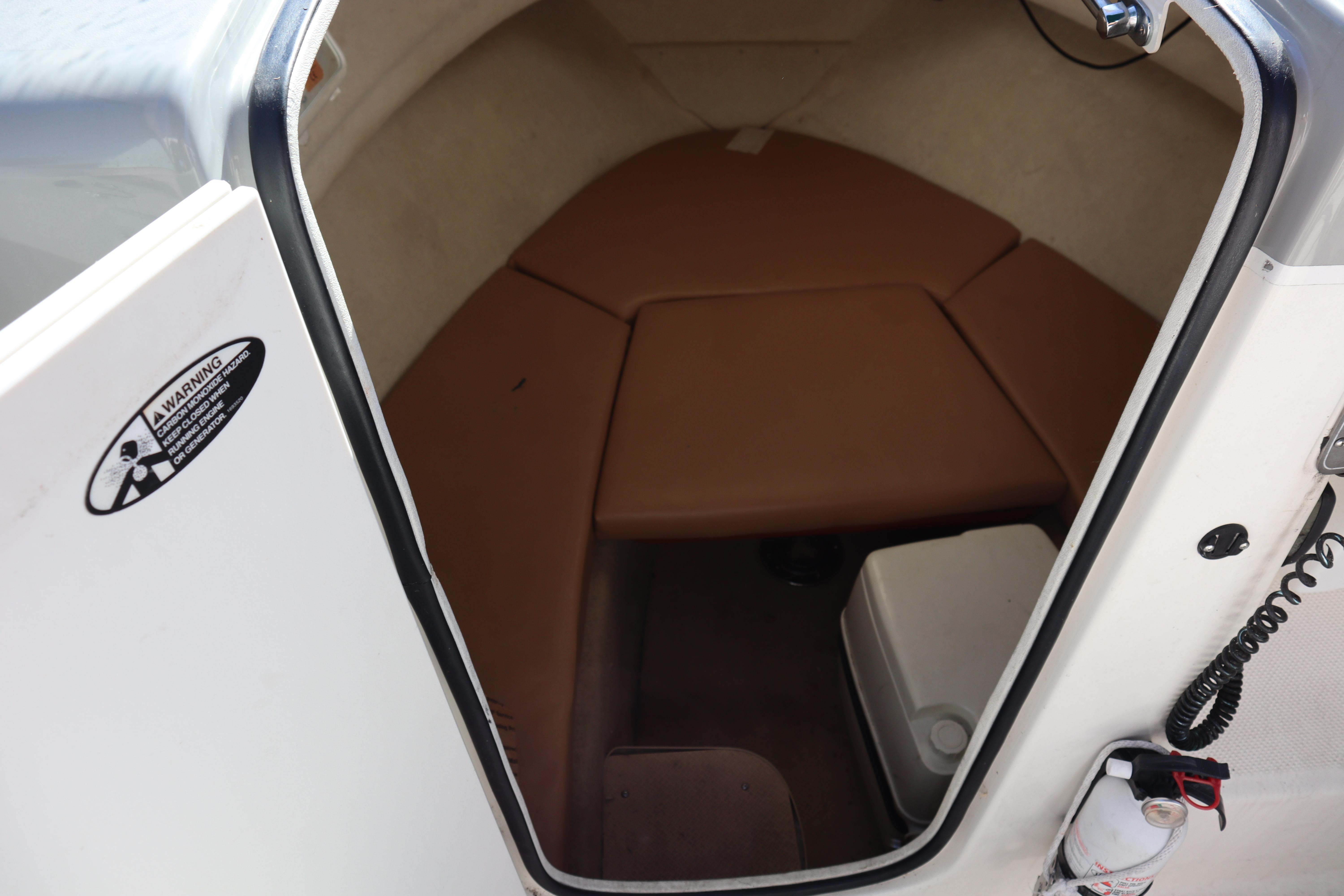 2008 Trophy 2102 Walkaround cabin interior with brown cushions and safety equipment.