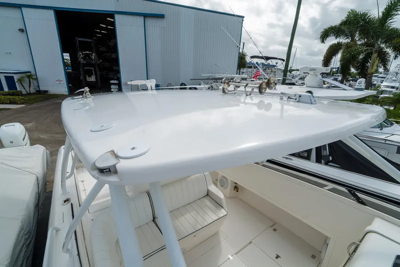  Yacht Photos Pics 2010 Intrepid 370 Cuddy boat, white deck, marina background, palm trees, and storage building.