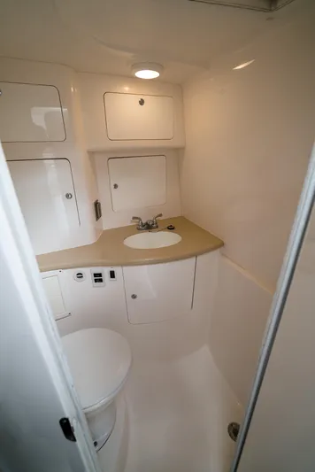  Yacht Photos Pics 2010 Intrepid 370 Cuddy boat bathroom with sink, toilet, and storage cabinets.