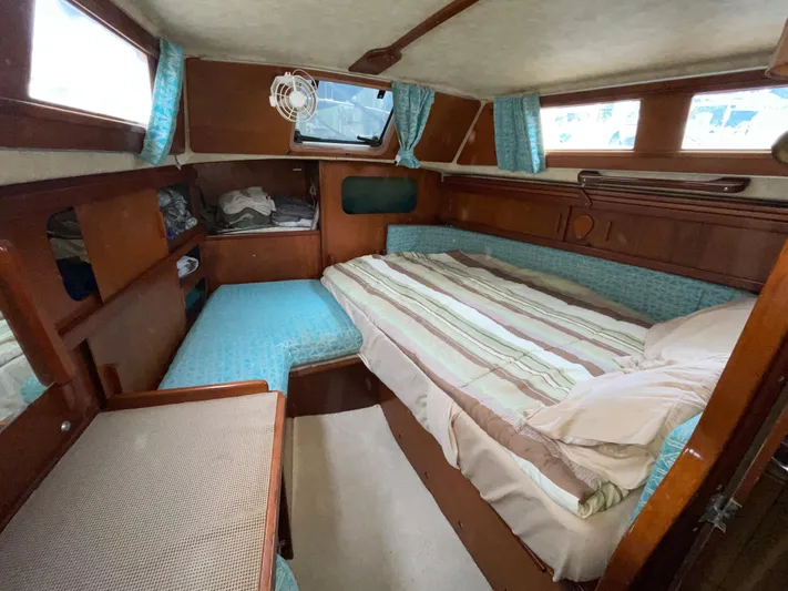 Bearaway Yacht Photos Pics 1985 Amel Maramu yacht cabin with cozy bed, wooden interior, and blue accents.