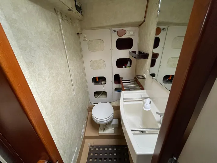 Bearaway Yacht Photos Pics 1985 Amel Maramu yacht bathroom with toilet, sink, and storage compartments.