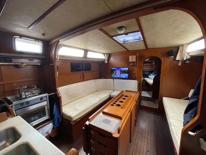 Bearaway Yacht Photos Pics Interior of 1985 Amel Maramu sailboat with cozy seating and kitchen area.