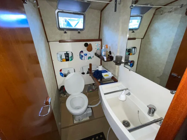 Bearaway Yacht Photos Pics Bathroom interior of 1985 Amel Maramu yacht with sink, toilet, and storage shelves.
