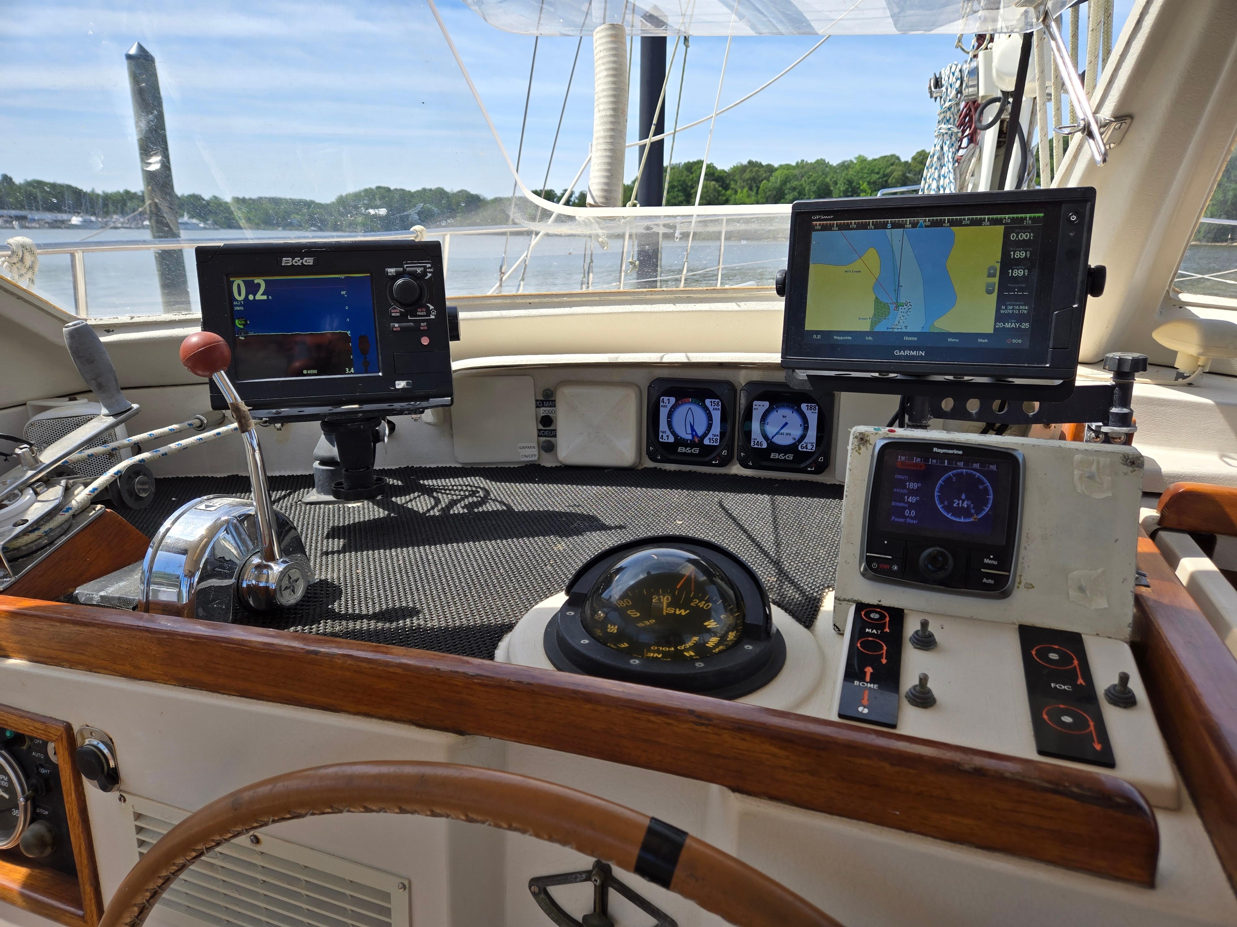 Cockpit of 1985 Amel Maramu sailboat with navigation instruments and steering wheel.