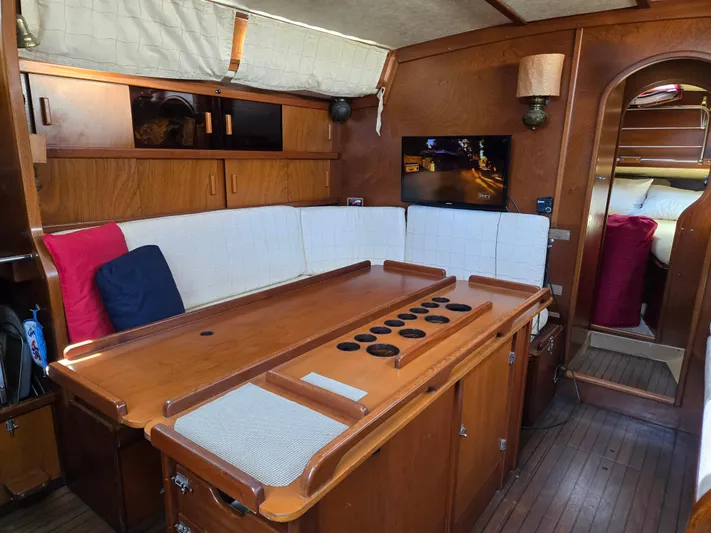 Bearaway Yacht Photos Pics Interior of 1985 Amel Maramu sailboat with wooden furnishings and cozy seating area.