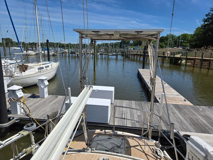 Bearaway Yacht Photos Pics 1985 Amel Maramu sailboat docked at a marina, surrounded by calm water and other boats.