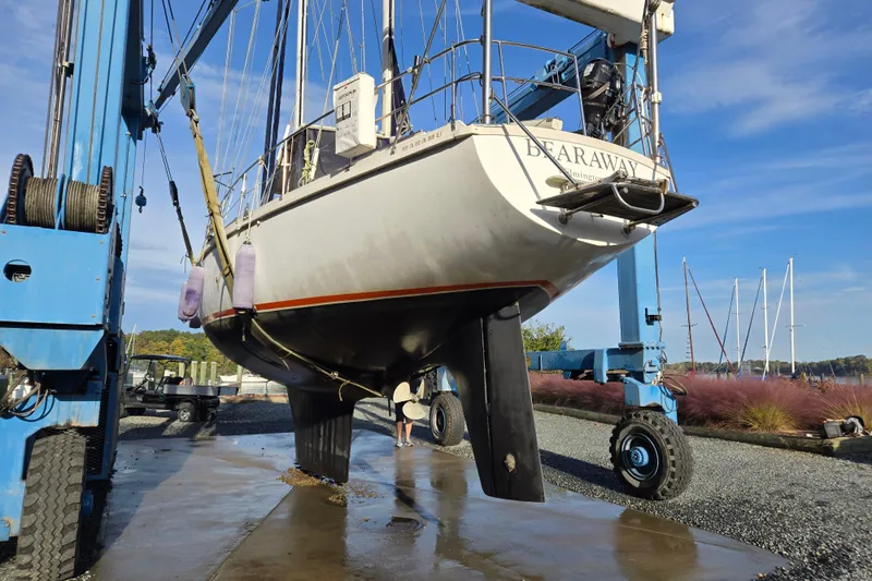 Bearaway Yacht Photos Pics 1985 Amel Maramu sailboat on a lift for maintenance at a marina.