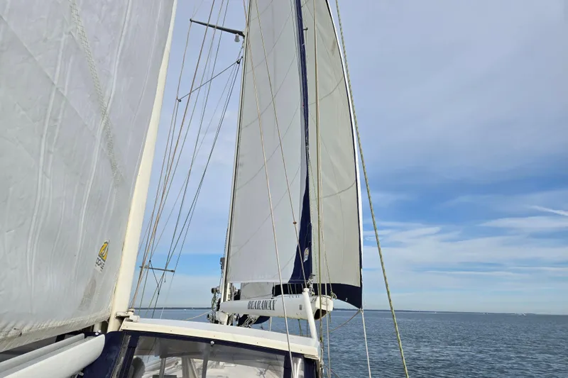 Bearaway Yacht Photos Pics Sailing yacht Amel Maramu 1985 with full sails on open sea under clear sky.