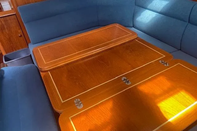 Ligera Yacht Photos Pics Interior of 2002 Jeanneau Sun Odyssey 45.2 yacht with wooden table and blue seating.