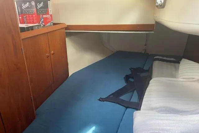 Ligera Yacht Photos Pics Interior cabin of 2002 Jeanneau Sun Odyssey 45.2 with blue bedding and storage.