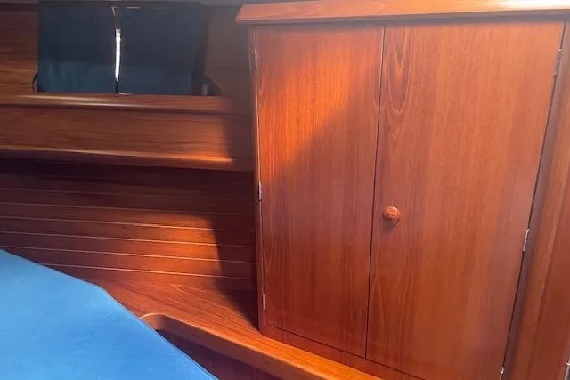 Ligera Yacht Photos Pics Interior of 2002 Jeanneau Sun Odyssey 45.2 yacht with wooden cabinetry and blue upholstery.