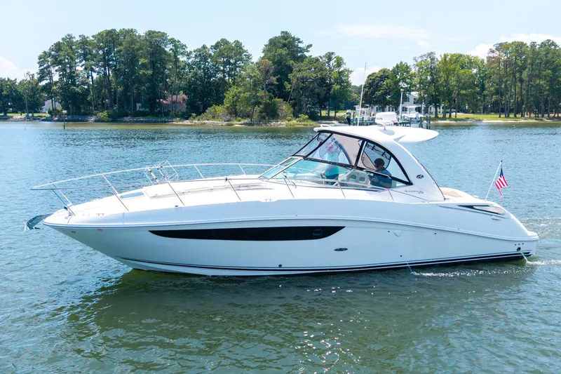 Latitude Adjustment Yacht Photos Pics 2013 Sea Ray 370 Sundancer cruising on a serene lake with lush green shoreline.