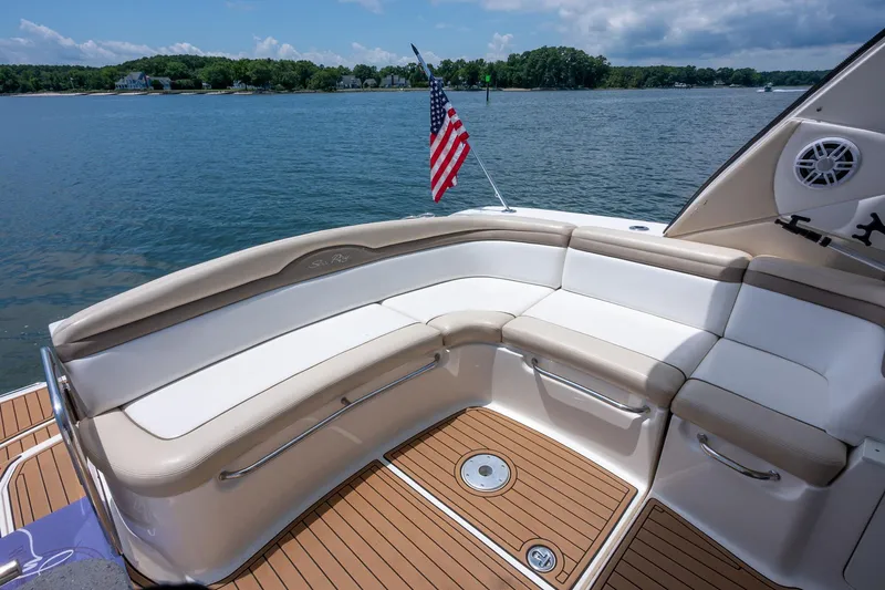 Latitude Adjustment Yacht Photos Pics Luxurious 2013 Sea Ray 370 Sundancer boat with elegant seating and American flag on calm water.