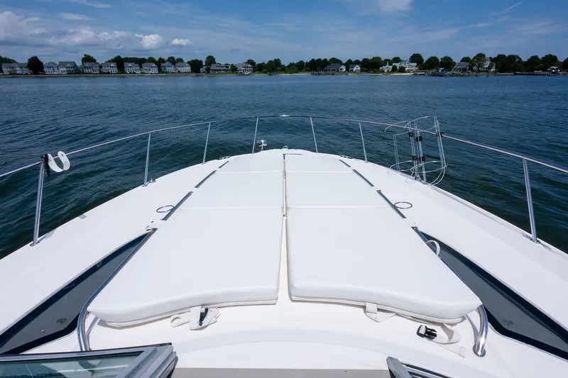 Latitude Adjustment Yacht Photos Pics 2013 Sea Ray 370 Sundancer boat deck with sun loungers, overlooking calm waters and distant shoreline.