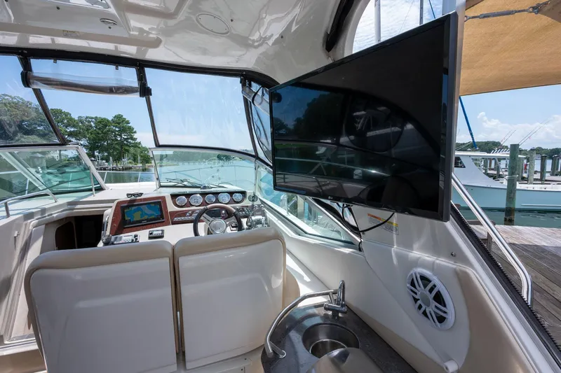 Latitude Adjustment Yacht Photos Pics 2013 Sea Ray 370 Sundancer cockpit with steering wheel, navigation system, and mounted TV.