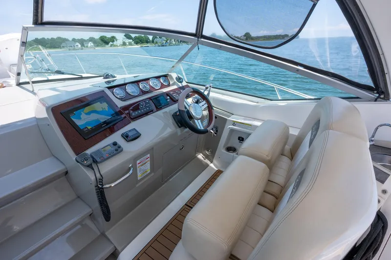 Latitude Adjustment Yacht Photos Pics 2013 Sea Ray 370 Sundancer helm with navigation system, steering wheel, and comfortable seating.