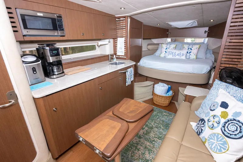 Latitude Adjustment Yacht Photos Pics Luxurious interior of 2013 Sea Ray 370 Sundancer yacht with cozy bed and kitchenette.