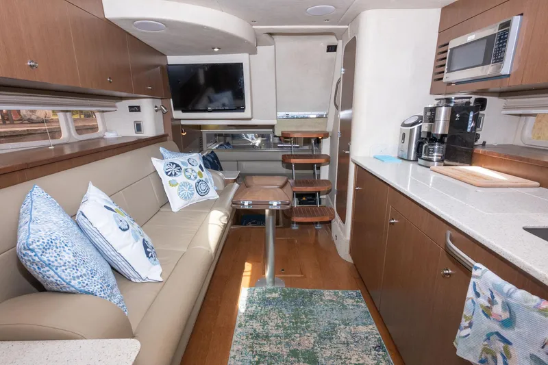 Latitude Adjustment Yacht Photos Pics Interior of 2013 Sea Ray 370 Sundancer yacht with modern kitchen and cozy seating area.