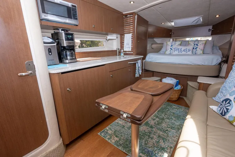 Latitude Adjustment Yacht Photos Pics Interior of 2013 Sea Ray 370 Sundancer yacht with kitchen and cozy sleeping area.