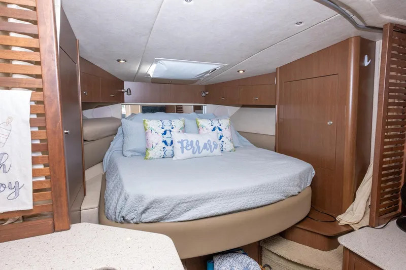 Latitude Adjustment Yacht Photos Pics Interior cabin of 2013 Sea Ray 370 Sundancer with cozy bed and wooden cabinetry.