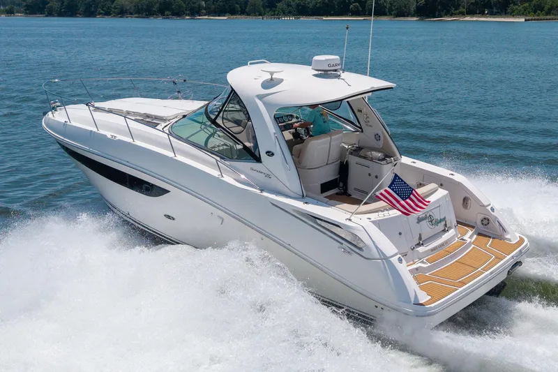 Latitude Adjustment Yacht Photos Pics 2013 Sea Ray 370 Sundancer cruising on water, American flag displayed, sunny day.