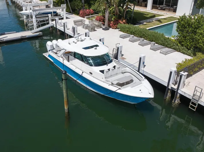  Yacht Photos Pics 2023 Tiara Yachts 48 LS docked by a luxurious waterfront property.