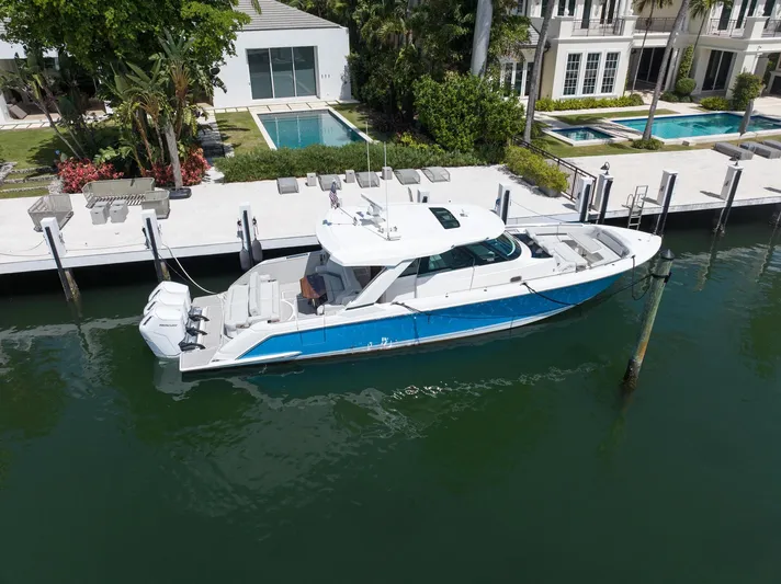  Yacht Photos Pics 2023 Tiara Yachts 48 LS docked by luxury waterfront homes.