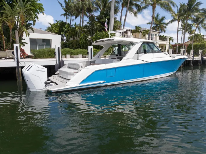  Yacht Photos Pics 2023 Tiara Yachts 48 LS in vibrant blue, docked by palm trees.