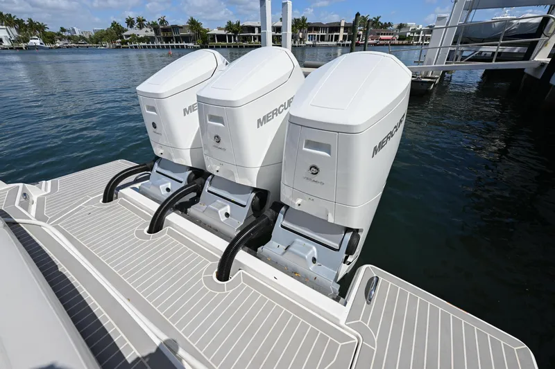  Yacht Photos Pics 2023 Tiara Yachts 48 LS with triple Mercury outboard engines on a sunny waterfront.