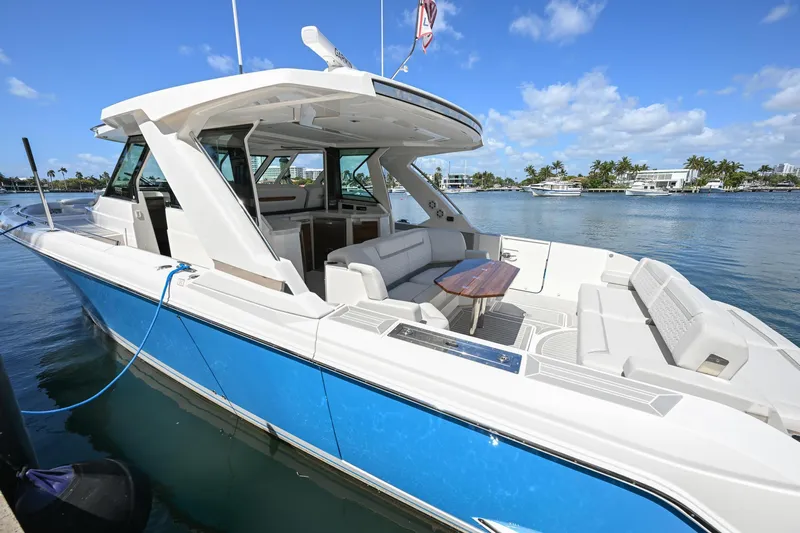  Yacht Photos Pics 2023 Tiara Yachts 48 LS, luxury boat docked, blue hull, spacious seating, sunny day.