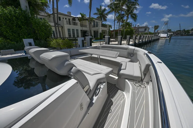  Yacht Photos Pics 2023 Tiara Yachts 48 LS luxury boat docked by waterfront homes under clear blue skies.